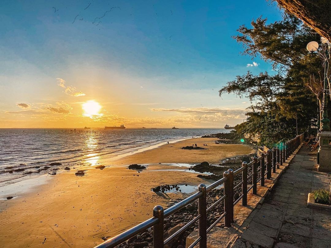 Dau Beach's golden sunset illuminating the historic Duc Me Bai Dau Church perched on hilltop overlooking the sea 